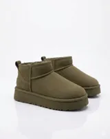 Botas tipo pantubota color camel, confeccionadas en material gamuzado con interior de piel sintética y suela de plataforma plana.