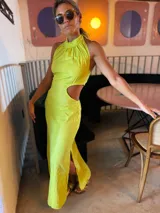 Vestido largo color lima con cuello halter, espalda descubierta, abertura lateral en la falda y recorte en la cintura.