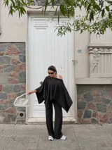 Pantalón de lanilla color negro, de corte recto y tiro alto, con diseño holgado y fluido.