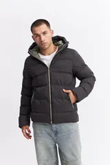 Campera puffer con capucha, diseño acolchado, cierre frontal y bolsillos laterales. Presenta un interior en contraste de color verde oliva.