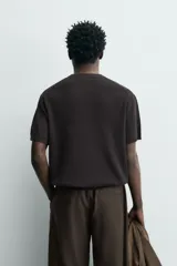 Camiseta de punto de algodón con textura perlada, corte regular fit, cuello redondo y manga corta con terminaciones en rib.