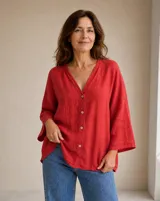 Camisa roja de lino, con cuello en V, mangas tres cuartos y cierre frontal de botones.