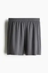 Short deportivo de tejido funcional de secado rápido, con cintura elástica, cordón de ajuste oculto, bolsillos laterales y aberturas en el bajo.