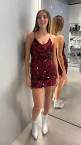 Vestido corto de fiesta color bordó, completamente cubierto de lentejuelas circulares. Presenta un diseño ajustado con escote en V y breteles finos.