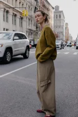 Jersey de punto negro, con cuello en V (pico) y manga larga, acabado en rib en puños, cuello y bajo.