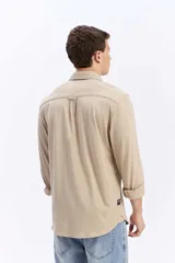 Camisa de manga larga color verde militar, con cuello tradicional y cierre frontal de botones.