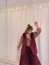 Chaleco largo de terciopelo color bordó, con corte recto y sin cierre.