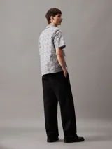 Camisa de hombre de manga corta con cuello cubano, corte boxy y estampado geométrico de rejilla en blanco y negro.