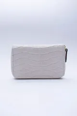 Billetera chica de cuero negro con textura tipo cocodrilo, cierre exterior, bolsillo para monedas con cierre en la parte trasera, múltiples ranuras para tarjetas y billetes, y forro rojo.