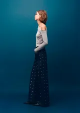 Jeans wide leg de tiro medio, confeccionados en denim azul oscuro con apliques de cristales distribuidos en toda la prenda. Cuenta con diseño de cinco bolsillos, trabillas para cinto y cierre frontal con botón y cremallera.