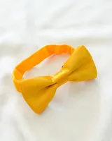 Moña amarilla para niño con lazo ajustable.