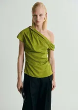 Blusa verde manzana de satén con escote asimétrico, un hombro descubierto y detalle drapeado.