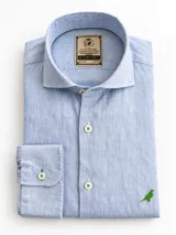 Camisa de lino celeste slim fit, con cuello italiano, manga larga y bordado de un loro verde en el pecho.