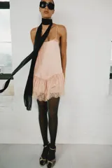 Vestido corto de estilo lencero, color rosado, con escote redondo, tirantes finos ajustables, bajo acabado en volante y detalles de encaje combinado a tono.