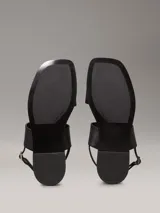 Sandalias planas Calvin Klein de cuero sintético negro, con puntera cuadrada, doble tira ancha y correa ajustable en el tobillo.