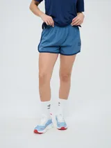 Short deportivo Umbro color celeste con ribetes y detalles en azul marino en los laterales, cuenta con cintura elástica y el logo de la marca estampado en la pierna izquierda.