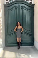 Vestido corto de corte ajustado con escote tipo bustier y tirantes finos. Presenta costuras verticales que definen la silueta y cierre posterior con cremallera oculta.