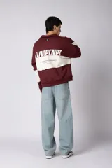 Buzo tipo polo de calce relajado con diseño de bloques de color en tonos marrón y blanco. Presenta cuello polo, cierre frontal parcial y logo estampado en el pecho. Confeccionado en tejido pesado con estructura.