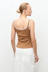 Top de canalé color tostado con ribetes blancos en el cuello y las sisas, de corte ajustado y sin mangas.