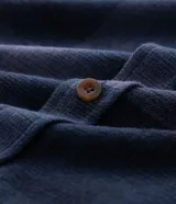 Camisa de franela a cuadros en tonos de azul marino y gris oscuro, con corte regular, manga larga, cuello camisero, cierre frontal de botones y un bolsillo en el pecho.