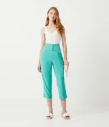 Pantalón capri color verde agua, de tiro alto, con cintura ancha, pala sobrepuesta con pespuntes y botones forrados.
