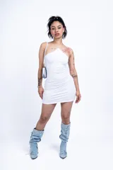 Vestido corto blanco de corte ajustado, con escote halter asimétrico y tirante fino en un hombro.