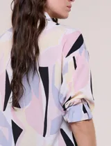 Blusa de gasa con estampado abstracto en tonos rosado, celeste, beige y negro, de silueta holgada, con cuello camisero, escote en V con media abotonadura y mangas largas de hombro caído.