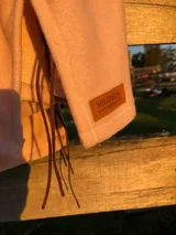 Sweater de tejido de punto suave en color rosado, con diseño holgado, cuello redondo y aberturas laterales en el ruedo.