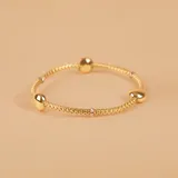 Pulsera de malla extensible en oro amarillo y blanco de 18k, con detalle de esfera central pulida.