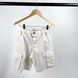 Bermuda cargo color arena confeccionada en gabardina, con bolsillos laterales tipo cargo y corte a la rodilla.