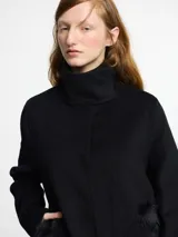 Tapado de paño color beige con chaleco desmontable de piel sintética.