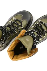 Borcego de cuero verde con detalles en marrón y negro, con cordones y suela track.