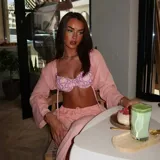 Conjunto de bikini estampado con flores y hojas en tonos rosados, amarillos y verdes. Incluye corpiño con aro y bombacha con lazos laterales.