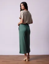 Pantalón capri plisado color beige, marca Dictionary, con pretina ancha elastizada y bolsillos delanteros.