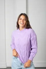 Buzo de tejido de punto con diseño de ochos, cuello redondo y mangas largas con puños acanalados.