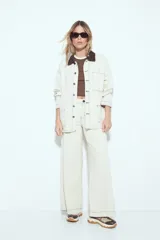 Sobrecamisa tipo Barn Jacket color marrón oscuro, de algodón con elastano, silueta relajada y estructura firme. Presenta cierre frontal con botones metálicos, cuello negro, bolsillos aplicados y pespuntes visibles.