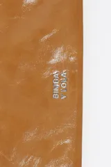 Bolso mini de piel vacuna color marrón, con diseño compacto y funcional. Presenta asa combinada de piel y cordón ajustable, logo metálico de la marca en el frente y cierre de cremallera.