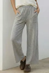 Pantalón de corte recto y tiro medio, confeccionado en tejido de algodón con diseño de rayas verticales finas. Presenta cintura elástica y bolsillos delanteros.