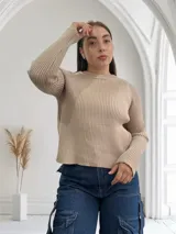 Sweater beige de punto acanalado con cuello redondo y mangas largas.