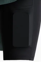Short deportivo de doble capa color verde con calzas cortas negras incorporadas en el interior. Cuenta con tecnología DryMove™, cintura elástica negra con cordón ajustable, bolsillos laterales y aberturas en el bajo.