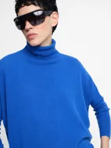 Sweater de cuello alto en punto acanalado, color verde menta, con mangas ajustadas y cuerpo amplio y suelto.