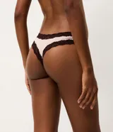Kit de dos bombachas tipo bikini confeccionadas en microfibra, con detalles de encaje contrastante en los bordes y un pequeño lazo decorativo en el centro. Una pieza es de color beige y la otra de color marrón oscuro.