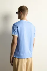 Camiseta de corte regular en color azul, con cuello en pico y bordes de las mangas en color amarillo a contraste.