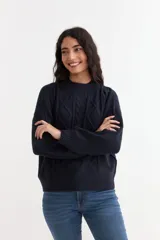 Sweater de punto color azul marino, con diseño de ochos en el frente, escote redondo y mangas largas con puños acanalados.