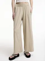 Pantalón recto color beige con pretina elástica y bolsillos laterales.