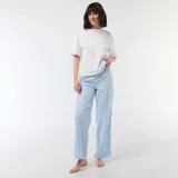 Pantalón de pijama de corte recto y holgado, confeccionado en popelina de algodón con estampado de rayas verticales celestes y blancas, y pequeños detalles decorativos. Cuenta con cintura elástica para mayor comodidad.