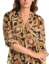 Blusa de gasa marca Floral & Ivy con estampado de arabescos en tonos tierra. Presenta cuello a la base con escote en V, mangas tres cuartos con sistema de ajuste mediante presilla y botón.