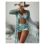 Conjunto de traje de baño de tres piezas con estampado de hojas tropicales en tonos blanco y negro. Incluye un top tipo tankini con cordón ajustable en el centro, un short de tiro alto y una camisa abierta de manga larga tipo salida de baño.