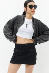 Minifalda de jean negra con cuatro bolsillos y dos bolsillos adicionales con cierre.