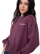 Buzo de cuello redondo color violeta, con corte relajado y mangas largas. Presenta el logo de la marca bordado en el pecho en color blanco.